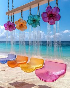 colorful glass flowers hanging from chains on the beach