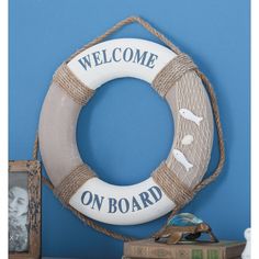 a life preserver with the words welcome on board attached to it next to an old book