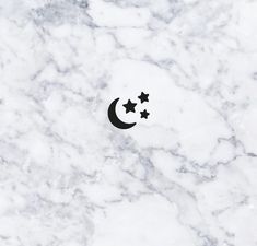 three stars and a crescent on a white marble surface with black dots in the middle