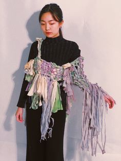 a woman standing in front of a white wall