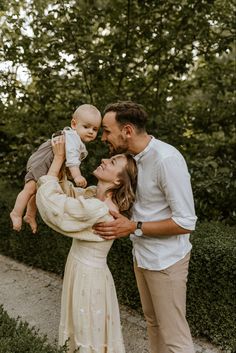 a man and woman holding a baby in their arms