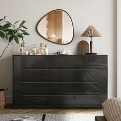 a living room with a large mirror on the wall next to a dresser and chair