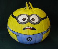 a yellow and blue painted pumpkin with a minion face