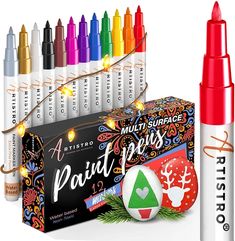 an assortment of crayons and markers are shown in front of a box with christmas decorations