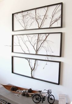 three framed pictures hanging on the wall in a room with wood floors and white walls