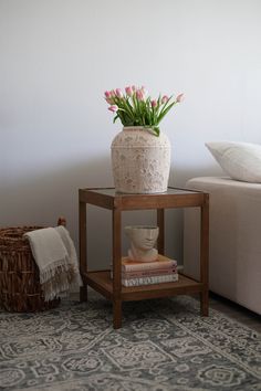 a small table with a vase and flowers on it