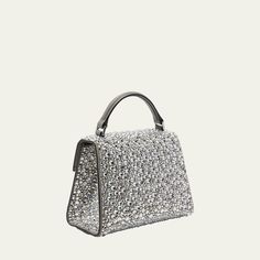 Valentino Garavani "VSLING" top handle bag in allover rhinestones and leather  Flat top handle  Detachable, adjustable shoulder strap Can be worn as a top handle or shoulder bag  Flap top with VLOGO lift clasp closure  Interior, one card slot  Feet protect bottom of bag  Approx. 5.1"H x 7.5"W x 3.9"D Made in Italy High-end Silver Top Handle Bag, Designer Silver Evening Bag With Top Handle, Luxury Silver Satchel Evening Bag, Silver Evening Bag With Detachable Strap, Luxury Silver Top Handle Evening Bag, Silver Evening Bag With Top Carry Handle, Elegant Leather Shoulder Bag With Rhinestones, Silver Leather Bag With Rhinestones, Silver Satchel Evening Bag