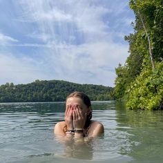 a woman in the water covering her face