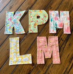 the letters k, p, l, m are laid out on a wooden surface