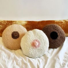 three round pillows sitting on top of a bed