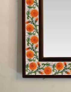 an orange flower painted on the side of a wooden frame with a mirror above it