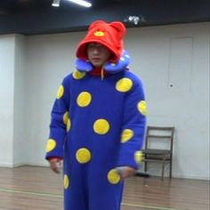 two people dressed in costumes standing on a wooden floor with one person wearing a clown costume