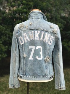 Custom denim jacket with beautiful HAND SEWN rhinestone brooches! Add your nickname, initials, NEW name, etc! A MAXIMUM of 10 letters across. Color variation may occur due to wash of jacket. Jackets may vary slightly in style depending on availability. INFORMATION TO INCLUDE IN NOTE TO SELLER UPON PURCHASE: -size (women's fitted sizing) -placement of letters if requesting different place than shown Please message for any specific questions! I LOVE creative requests or themes... Message me for mo Black Jacket Outfit, Jean Jacket Design, Jacket Inspiration, Jersey Ideas, Football Ideas