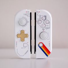 a nintendo wii controller with a gold and red ribbon around the front part, on a white surface