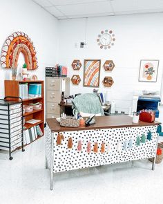 an office with lots of clutter on the desk and shelves in front of it