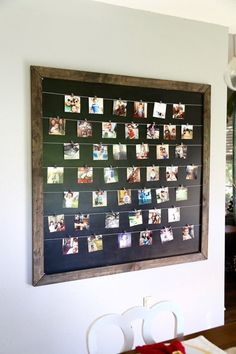 a blackboard with pictures hanging on it in a dining room next to a table