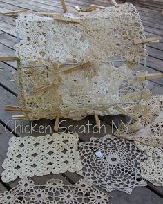 several pieces of crocheted doily laid out on a wooden floor