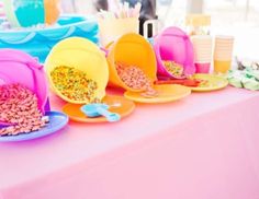 there are many plates and bowls on the table with food in them that is colorful