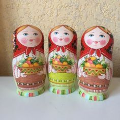 three nesting dolls are sitting next to each other on a table with a wall in the background