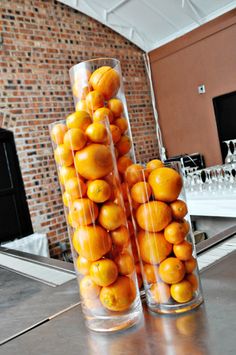 there are two tall vases filled with oranges