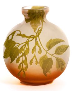 a glass vase with leaves painted on it