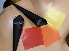 several pieces of paper and a black cone on a table