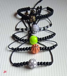 four bracelets with beads and balls on them