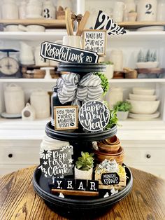 a black and white tiered tray with signs on it that say happy new year