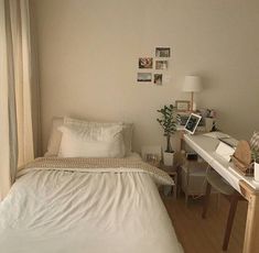 a white bed sitting next to a wooden desk