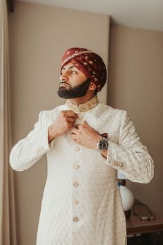 a man in a turban adjusting his tie