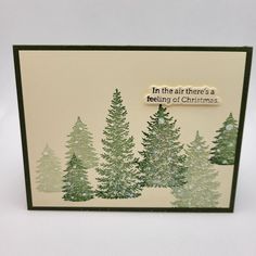 a handmade christmas card with pine trees and the words in the air there's a feeling of christmas