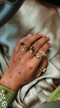 a woman's hand with red spots on her left wrist and two gold rings