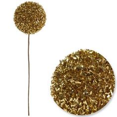 a golden glitter ball next to a gold stick on a white surface with the end cut out