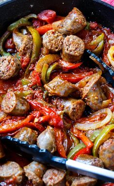 sausage and peppers in a skillet with tongs