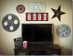 a flat screen tv sitting on top of a wooden table next to a movie projector