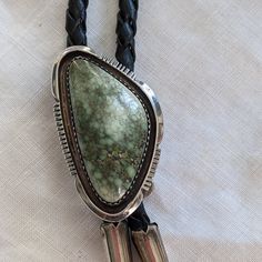 Michael Perry Navajo Sterling Silver Carico Lake Turquoise Bolo Tie. Handmade By Well-Known Master Navajo Silversmith Michael Perry. Signed Mp ( Michael Perry) And Stamped Sterling. Stone Measures 1.5" Long Please Note That There Is A Part In The Leather Braid With Some Frays ( See Photos) I Believe (But Not Certain As I Am Not A Jeweler) That The Stone Is Carico Lake Turquoise. The Turquoise Is A Mossy Earth Green Color With Hints Of Blue. “Carico Lake Turquoise Has An Astonishing Color Palette. Ranging From Highly Unique Electric Greens To Sky Blue; From Teal To Mossy, Earthy Greens. And Rarely, A Nugget With Both Earth And Sky Color.” Handmade Western Silver Turquoise Necklace, Adjustable Southwestern Silver Turquoise Necklace, Western Style Silver Turquoise Necklace For Ranch, Artisan Silver Jewelry For Rodeo, Western Silver Turquoise Necklace With Concho, Earth Green Color, Turquoise Bolo Tie, Earthy Greens, Earth And Sky