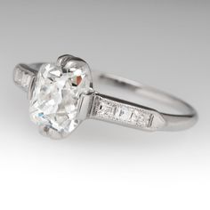 an old cut diamond ring with baguets on the shoulders and side stones set in white gold