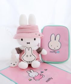 a small stuffed animal sitting next to a pink bag