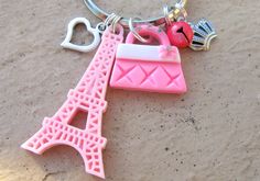 Adorable Charm Keychain!  Definitely One of a Kind! Silver tone keyring with 5 fun charms- ⭐️ Cute Eiffel Tower in a pale shade of pink ⭐️ Pink purse with a cute pink bow on it. The bow even has a rhinestone in the middle of it. There's rhinestones on the handle too.  ⭐️ Tiny bell- comes in handy when digging through your purse! - bell comes in your choice of silver or cream. Pink is sold out ⭐️ Silver tone heart charm in your choice of designed heart or heart key.  Plain heart is sold out ⭐️ Cute Silver Tone Crown Can be used as a keychain, purse charm, kid's backpack charm, etc. Backpack Charms, Pink Beret, Kawaii Keychain, Keychain Kawaii, Keychain Pink, Pink Keychain, Crown Charm, Keychain Purse, Backpack Charm