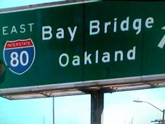 an interstate sign with the words bay bridge and oakland on it's left side