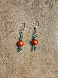 This pair is made with sterling silver fishhook, orange center bead and green Swarovski crystals. Orange Czech Glass Jewelry With Ear Wire, Orange Sterling Silver Jewelry With Round Beads, Beaded Jewelry Diy, Jewelry Diy, Beaded Earrings, Jewelry Earrings Dangle, Swarovski Crystals, Beaded Jewelry, Etsy Earrings