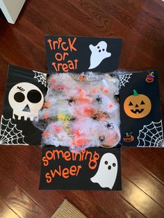 halloween treat bags with candy in them on a wooden floor next to a trick or treat sign