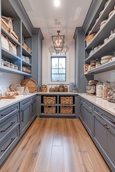 a large kitchen with gray cabinets and wooden flooring, along with white counter tops