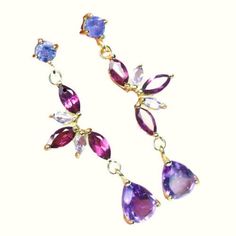 Colorful Multi-Gem Dangle Drop Earrings Pear-cut amethysts are suspended from clusters of marquise-cut rhodolite garnets & round-cut tanzanites on these stunning drop earrings.  The gemstones are all completely natural without lab enhancements of any kind. The gemstones measure from 2x4mm to6x8mm.  Each earring dimension is 35 x 9.8mm.  Each earring weighs 1.98 grams. The setting is 18k yellow gold over 925 sterling silver. These are from a late 1980s estate but they appear to be unworn.  These Purple Multi-stone Dangle Earrings, Purple Multi-stone Dangle Jewelry, Amethyst Multi-stone Drop Earrings, Purple Multi-stone Teardrop Earrings, Teardrop Multi-stone Amethyst Earrings, Purple Teardrop Multi-stone Jewelry, Purple Tanzanite Gemstone Earrings, Ear Drops, Client Satisfaction