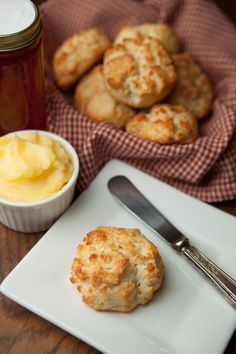 biscuits and butter on a plate with a cup of honey