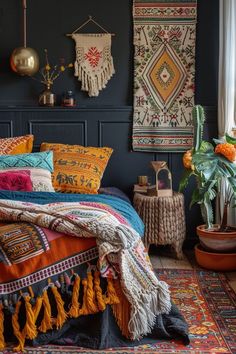 a bed with colorful blankets and pillows in a dark room next to a potted plant