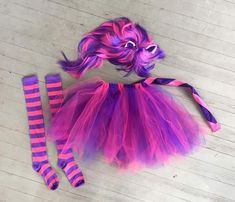 there is a purple and pink costume on the floor next to some striped tights