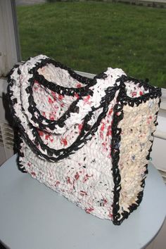 a handbag sitting on top of a white table next to a window sill