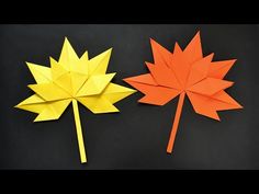 two pieces of paper that have been folded to look like maple leaves, one is orange and the other is yellow