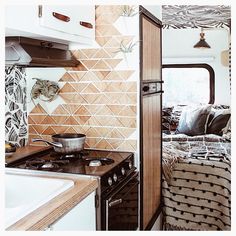 a kitchen with a stove top oven next to a sink under a window in a small room